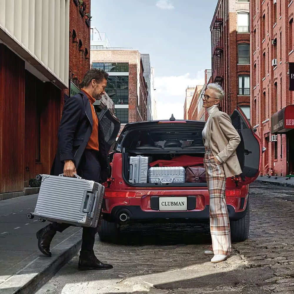 MAN AND WOMAN PACKING A MINI CLUBMAN WITH SUITCASES